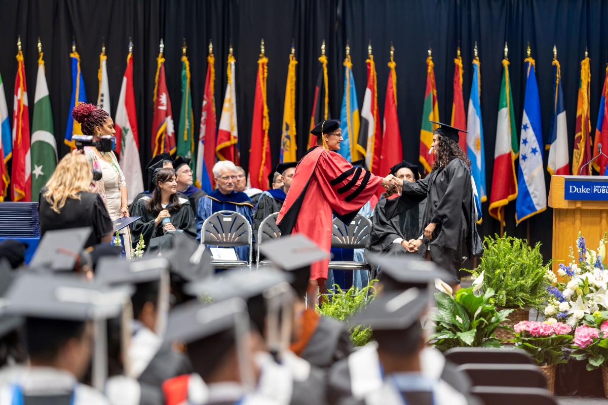 Dean shaking hand as student walks across stage. 