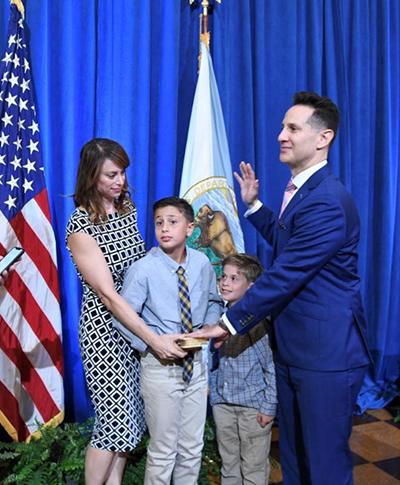 Man being sworn into public office with his family beside him