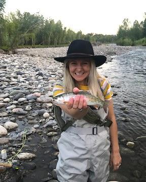 Woman smiling while holding a fish