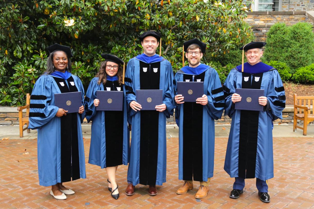 5 people, in robes, holding degrees