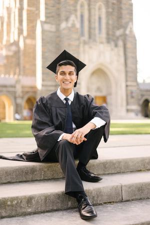student in cap and down smiling on steps