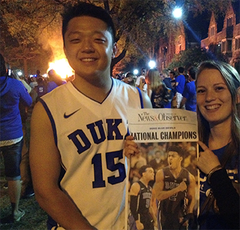 a couple holding a newspaper and celebrating