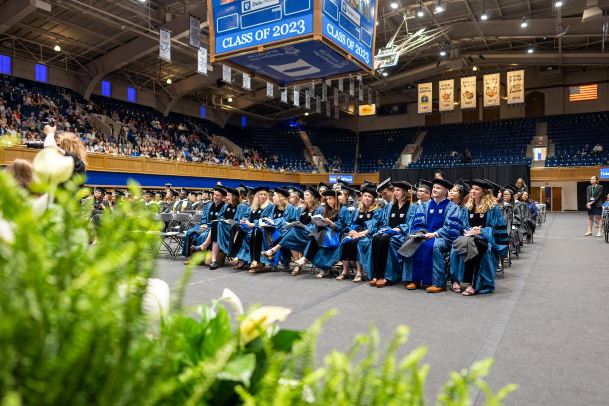 10 students sit in front row with blue robes. 