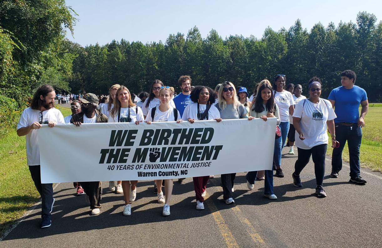 students walk with environmental justice banner