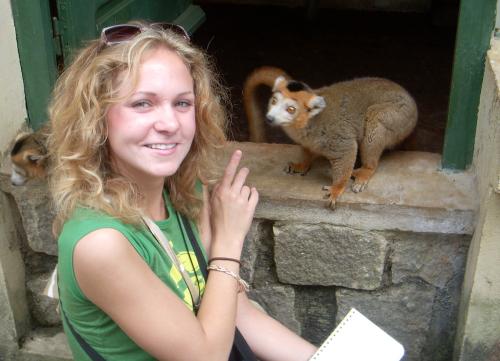 Woman smiling next to a lemur
