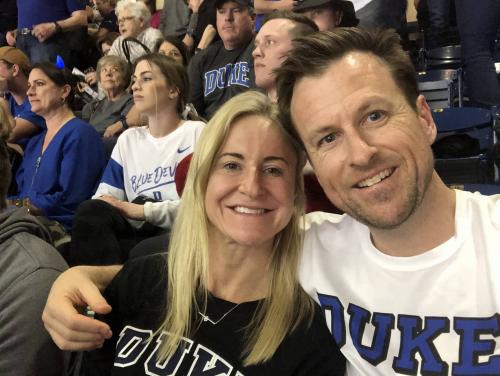 Man and woman, duke gear at game, smiling