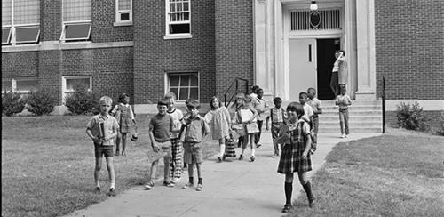 White children outside a school, black and white image