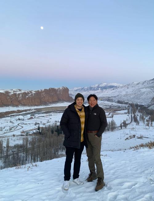 Beautiful night, moon in distance, two men outside, mountains