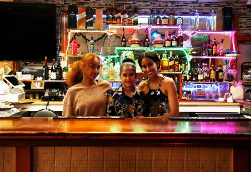 Mella with her mom and sister behind the bar
