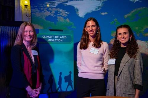 3 women in front of a map that says "Climate Migration"