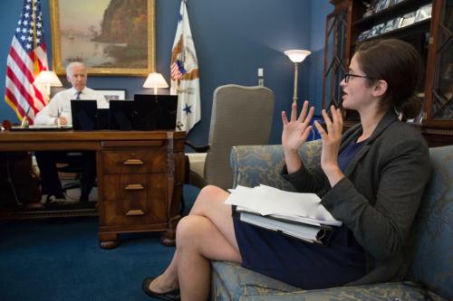 Woman gesturing. Biden behind his desk, listening