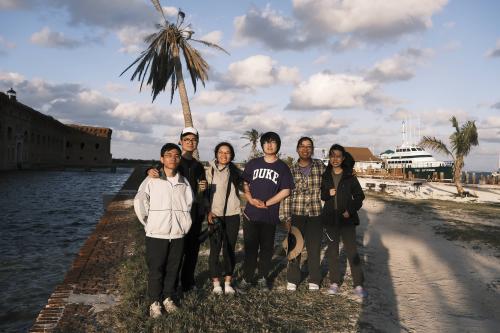 Students posing near boats and ocean