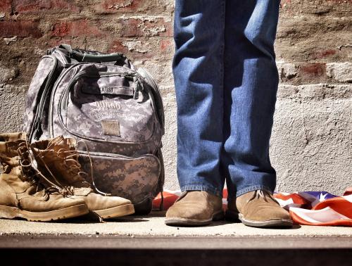 military backpack and boots, bottom half of legs, person in jeans
